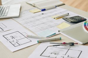 finding the hidden renovation costs using calculator, pens, layouts to factor in the budget