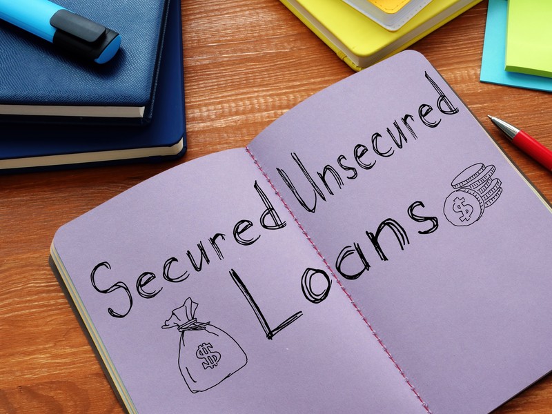 Notebook with secured loans and unsecured loans written on the pages